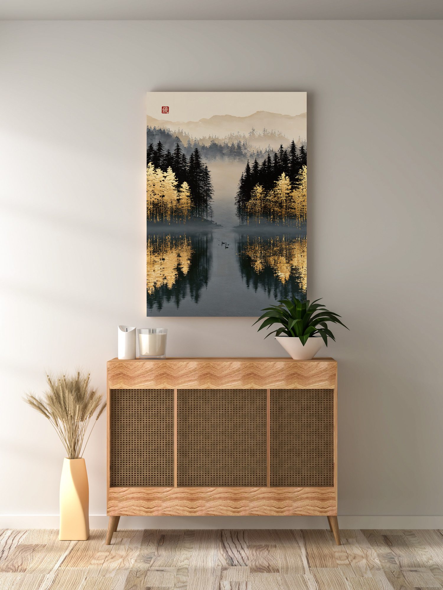 Still Lake of Golden Larches: golden larches and black pines stand at the edge of a still lake in the fog, mirrored in the dark water. A few ducks swim on the surface. A red seal sits in the upper left. The print hangs above a wooden cabinet with rattan doors. A plant in a white bowl on the cabinet reaches in front of the print's lower corner, next to candles. Dried grass in a tall vase stands on the floor to the left.
